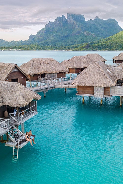 Maldives Vs Bora Bora For Couples: Which Is Better? Overwater bungalow deck at Four Seasons Bora Bora with lagoon and mountain views